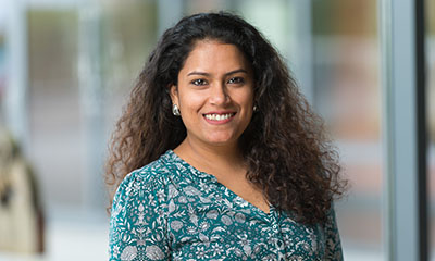 Anouksha Gardner, a woman in her 20s or 30s with brown curly hair and a green blouse